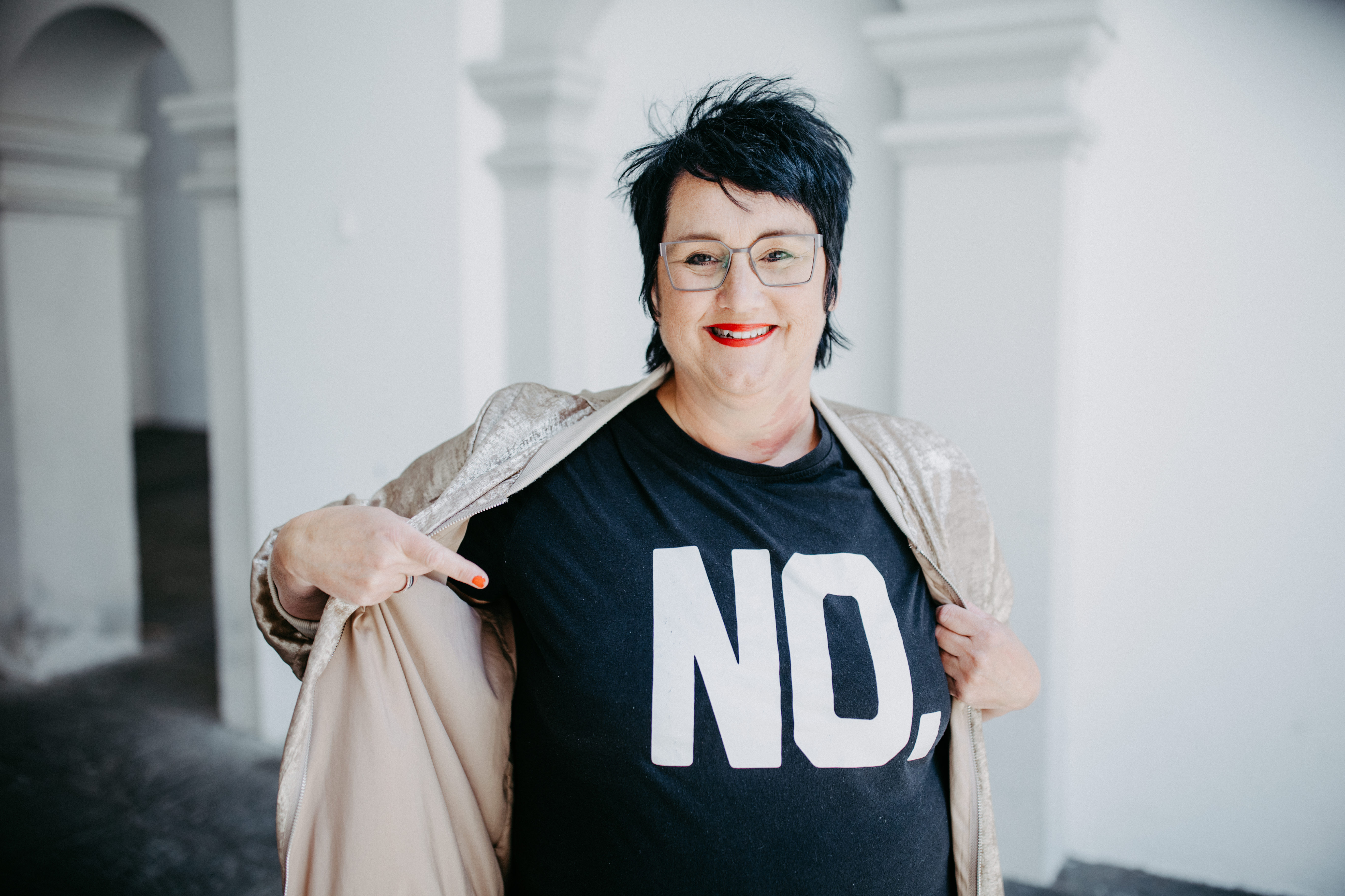 Sabine, Coach für Führungsfrauen steht mit einem schwarzen T-Shirt auf dem NO steht in Ravensburg.